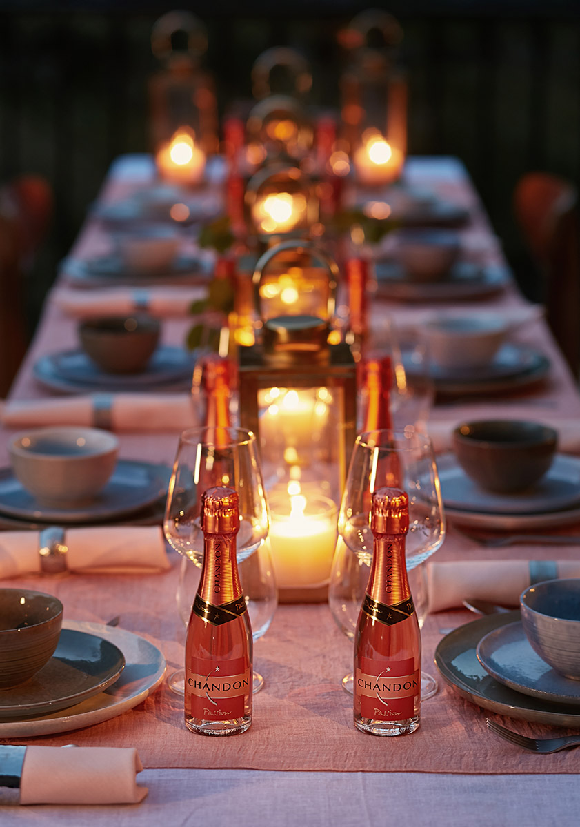 Table de soirée festive éclairée aux bougies et lanternes