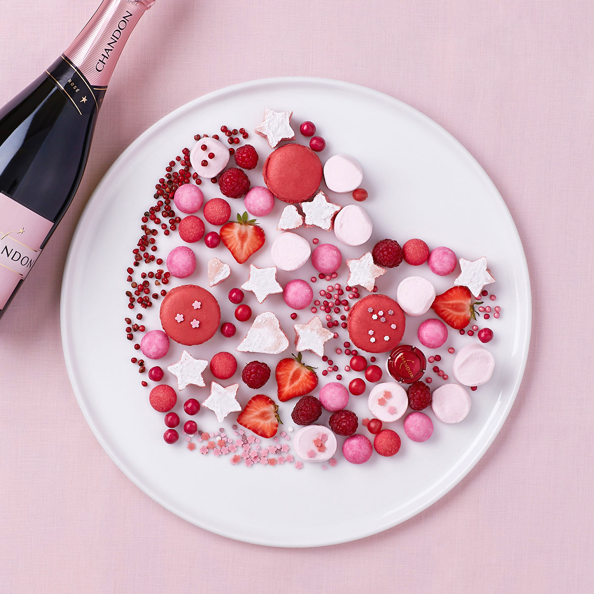 Topview composition en forme de cœur en sucreries roses, macarons, fraises, bonbons