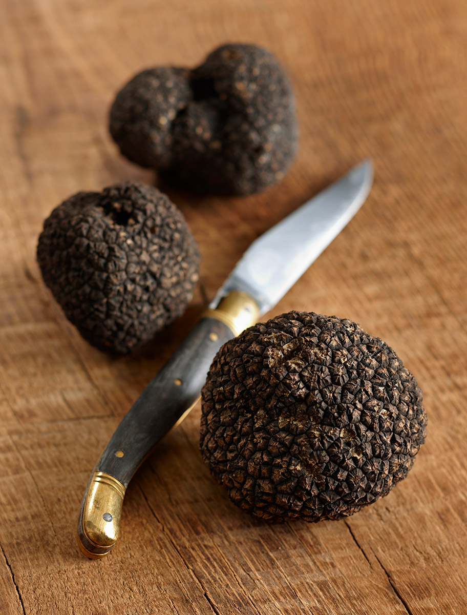 Truffes noires sur une planche en bois et couteau de Laguiole