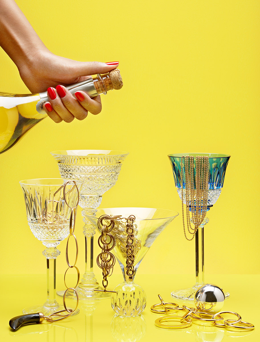 Bijoux or et bouteille de champagne pour Cosmopolitain magazine, fond jaune