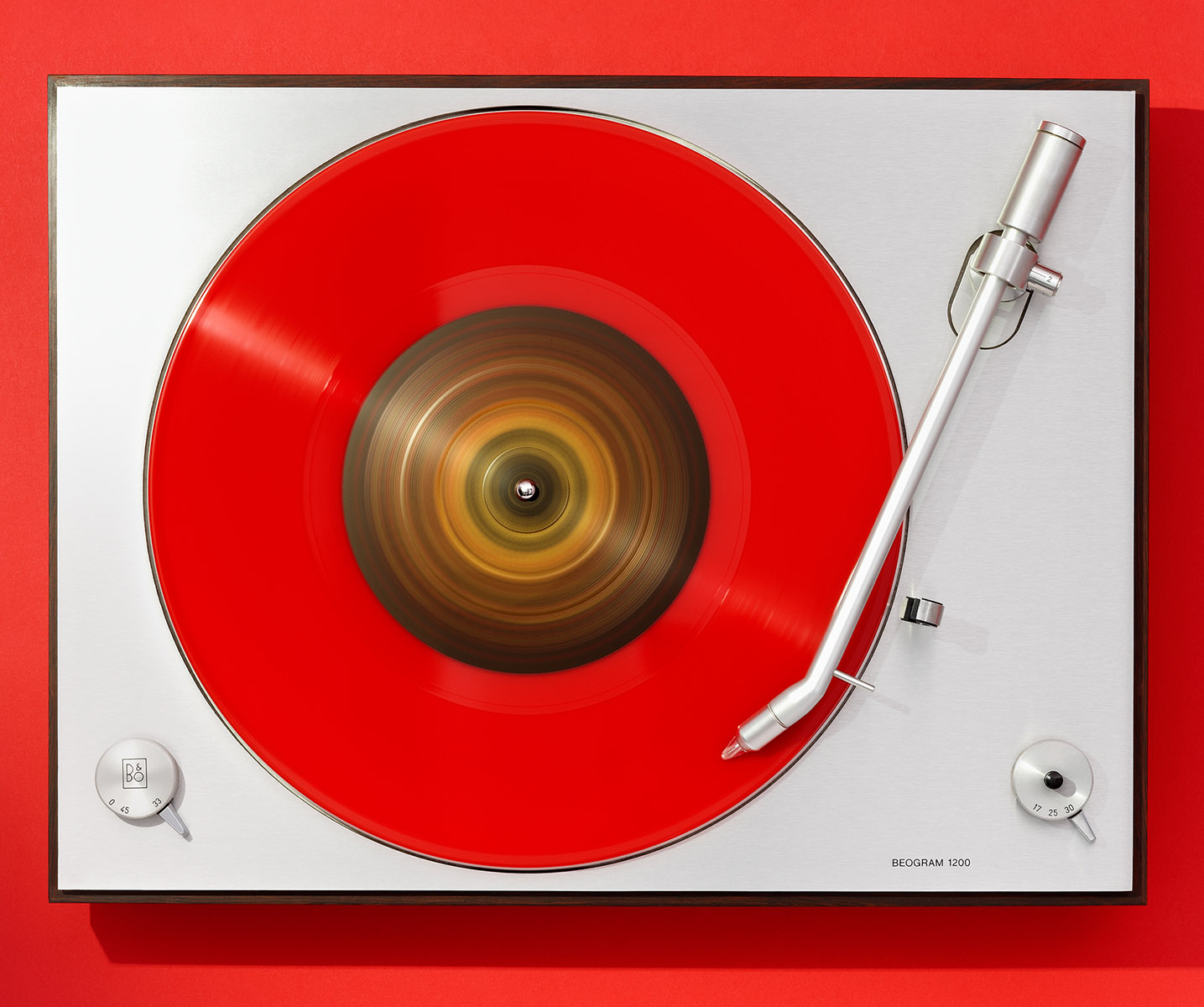 Platine disque vintage Bang & Olufsen, modèle Beogram 1200 et disque vinyl rouge maxi 45T, fond rouge